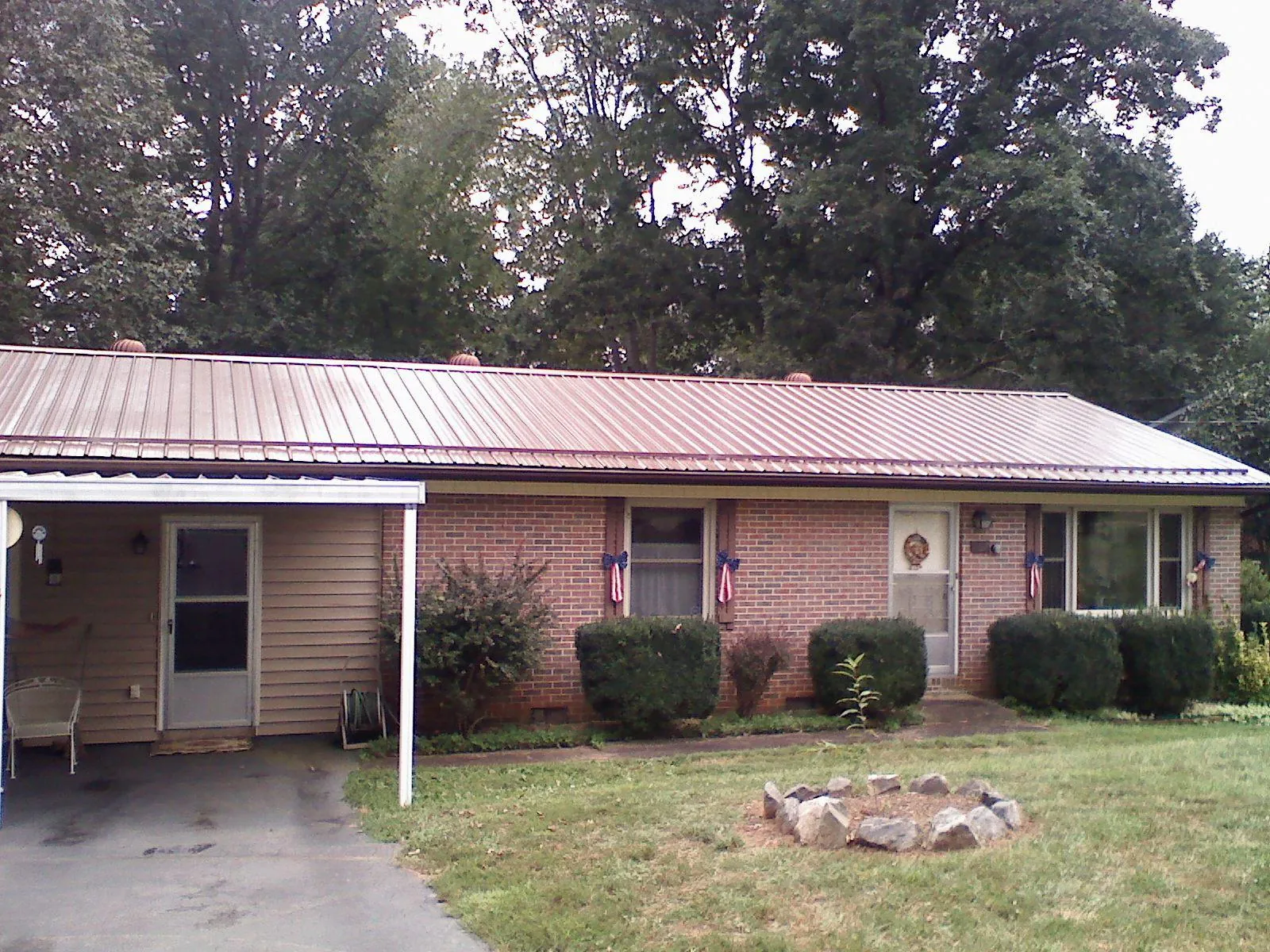 Bronze metal roof and carport on a brick ranch home — Roof Repair work by our crew in Worcester
